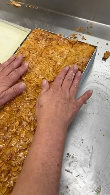 Blechkuchen wird von Hand belegt